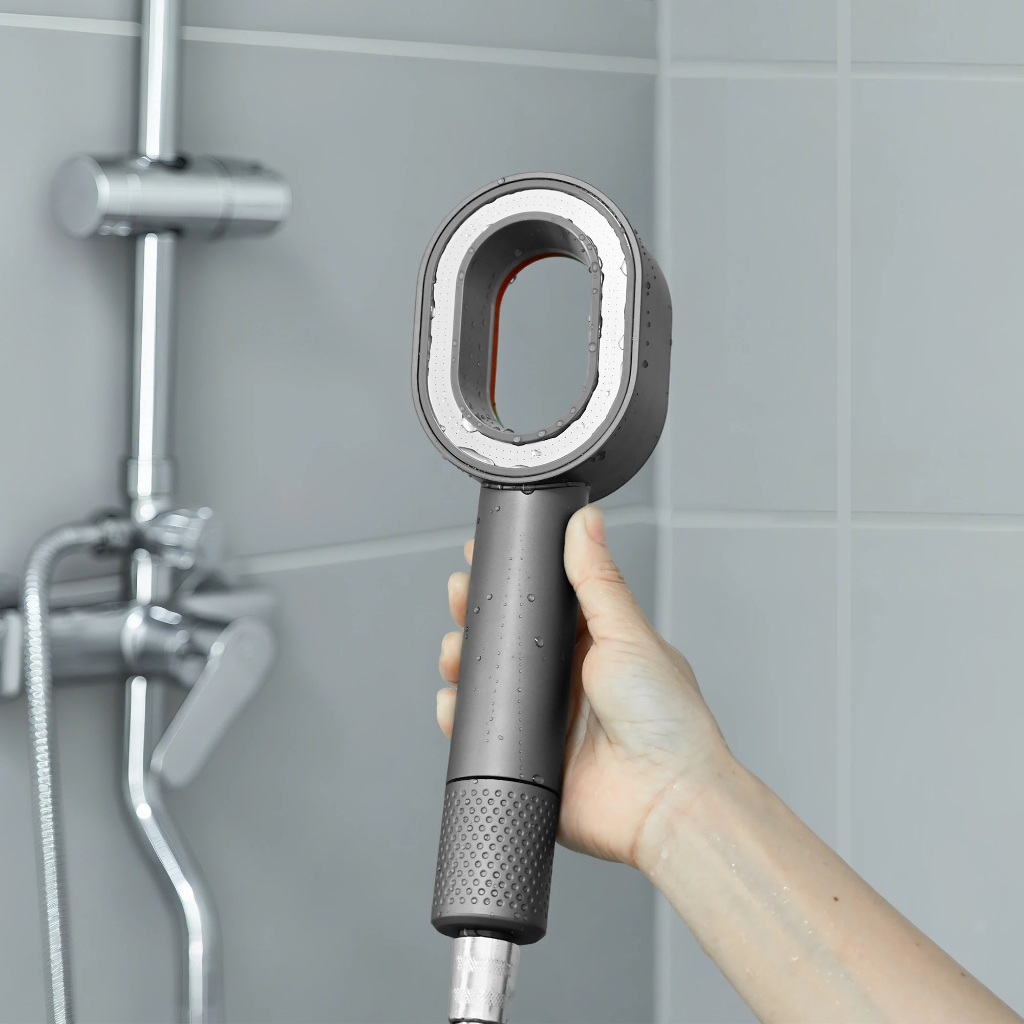 URBAN FALLS Handheld Shower Head held by a hand in a clean bathroom shower setting